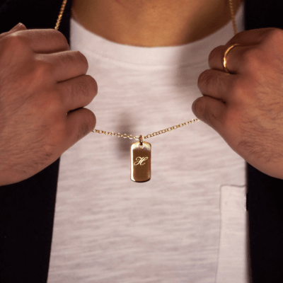 male model wearing gold engraved dog tag necklace