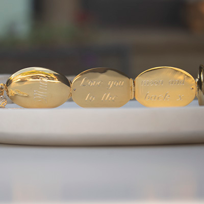 gold locket with an engraved message lying open