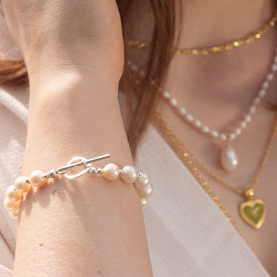 model wears an ivory pearl bracelet on her wrist