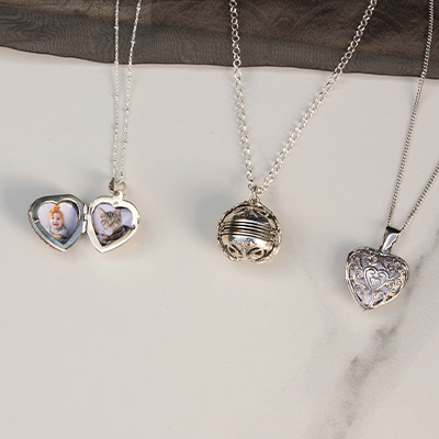 Three Lily Blanche silver pendants on a marble slab