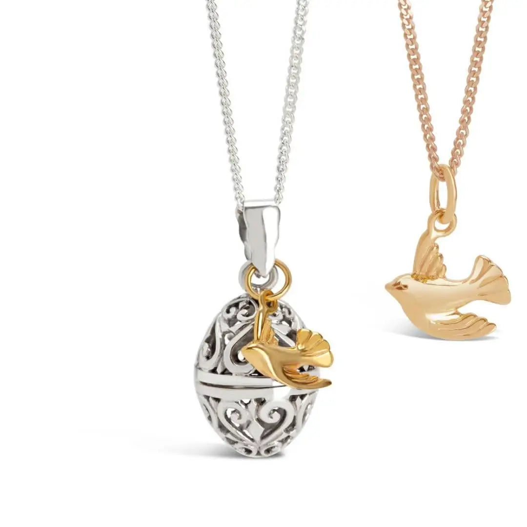 Gold bird charm pendant paired with filigree silver locket necklace, meaningful layered jewellery set