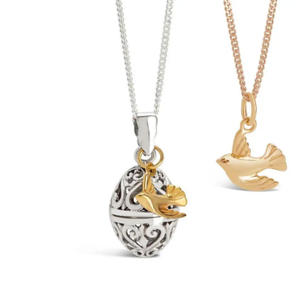 Gold bird charm pendant paired with filigree silver locket necklace, meaningful layered jewellery set