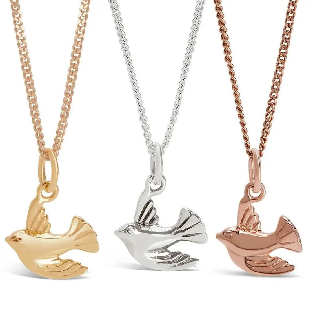 Bird charm necklaces in gold, sterling silver and rose gold, minimalist symbolic jewellery design