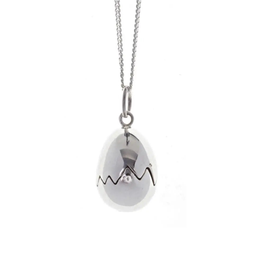Close-up of sterling silver egg locket pendant with jagged crack detail, high-polish finish and minimalist chain