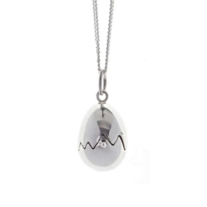 Close-up of sterling silver egg locket pendant with jagged crack detail, high-polish finish and minimalist chain