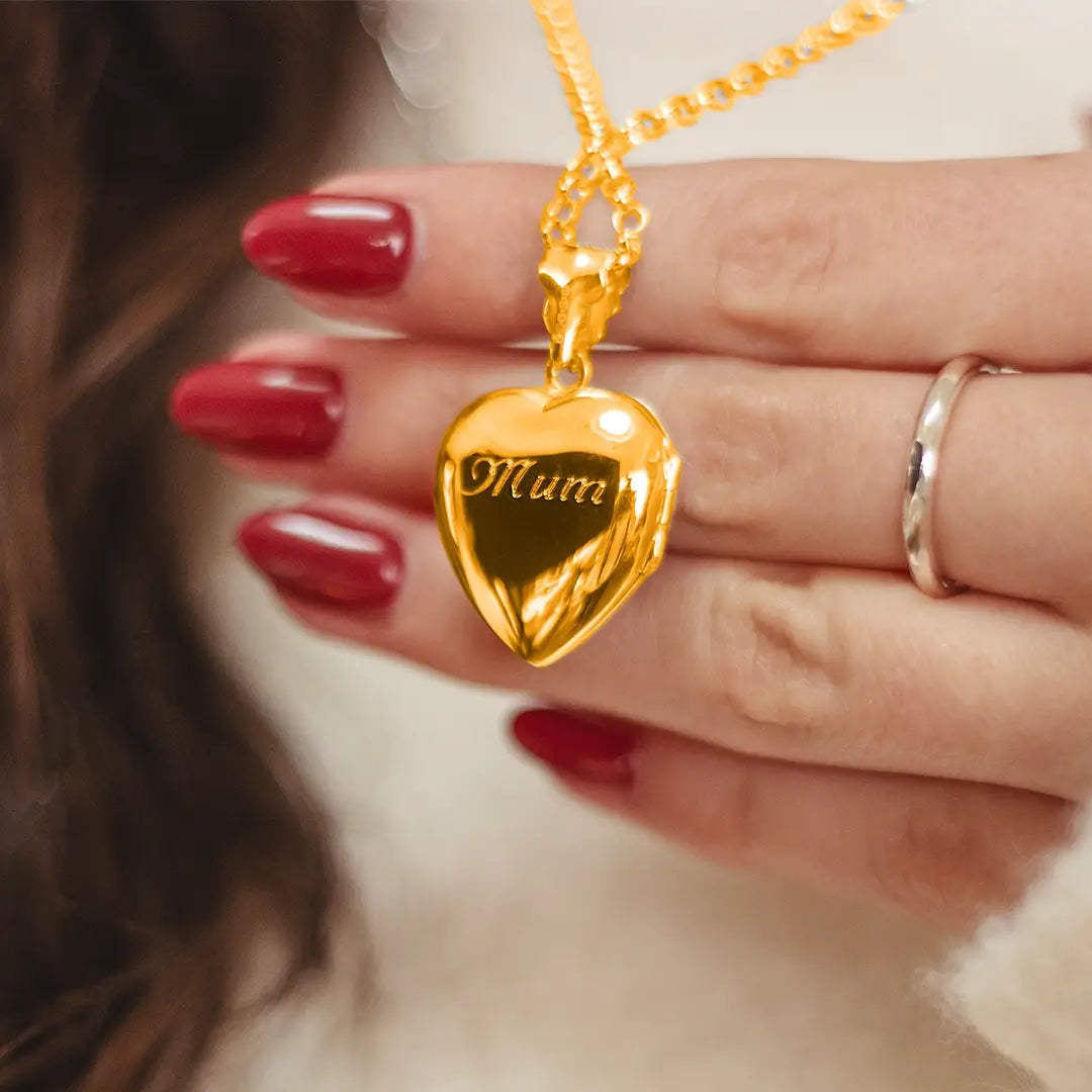 Close-up of gold heart locket necklace engraved with ‘Mum’ on polished back