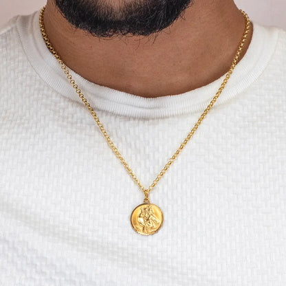 Men’s gold St Christopher pendant necklace worn on fine chain over white textured shirt