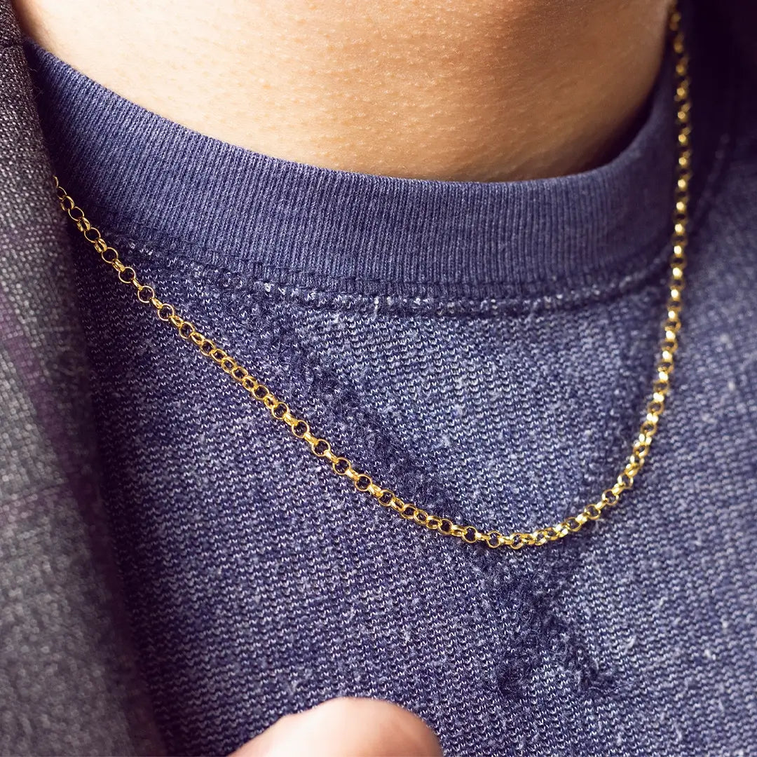 Detailed view of a gold vermeil belcher chain necklace on a navy textured sweater, highlighting the fine link design and polished finish.