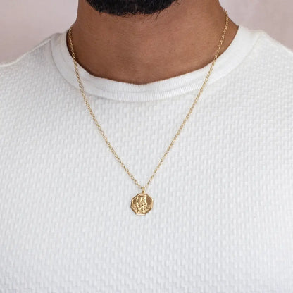 Men’s gold St Christopher hexagon pendant necklace worn on fine chain over white shirt
