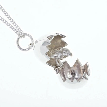 Detailed view of silver hatching chick locket pendant with hinged opening egg and textured chick interior