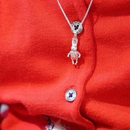 Sterling silver bunny pendant necklace worn on red knit cardigan, cute children’s jewellery gift