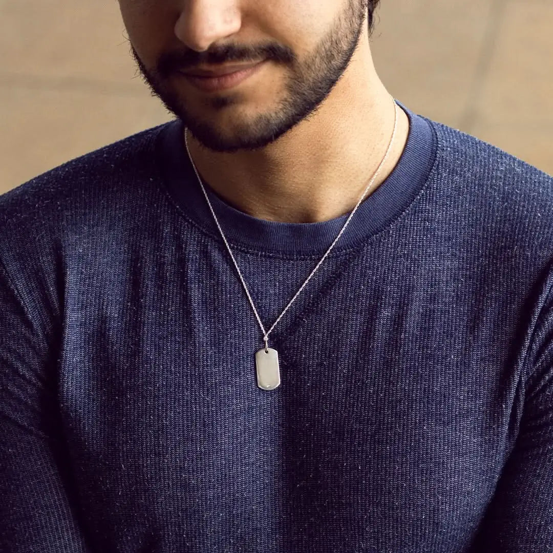 Sterling silver dog tag necklace with polished blank pendant worn by model, minimalist and modern men’s jewellery styling.