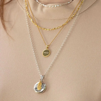 Layered sterling silver and gold necklaces with feather locket pendant, personalised keepsake jewellery styling