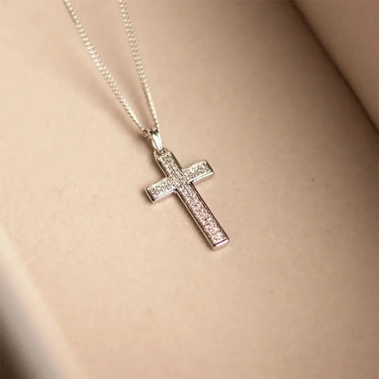 White gold pavé diamond cross necklace worn on skin, delicate fine chain and sparkling diamond detail