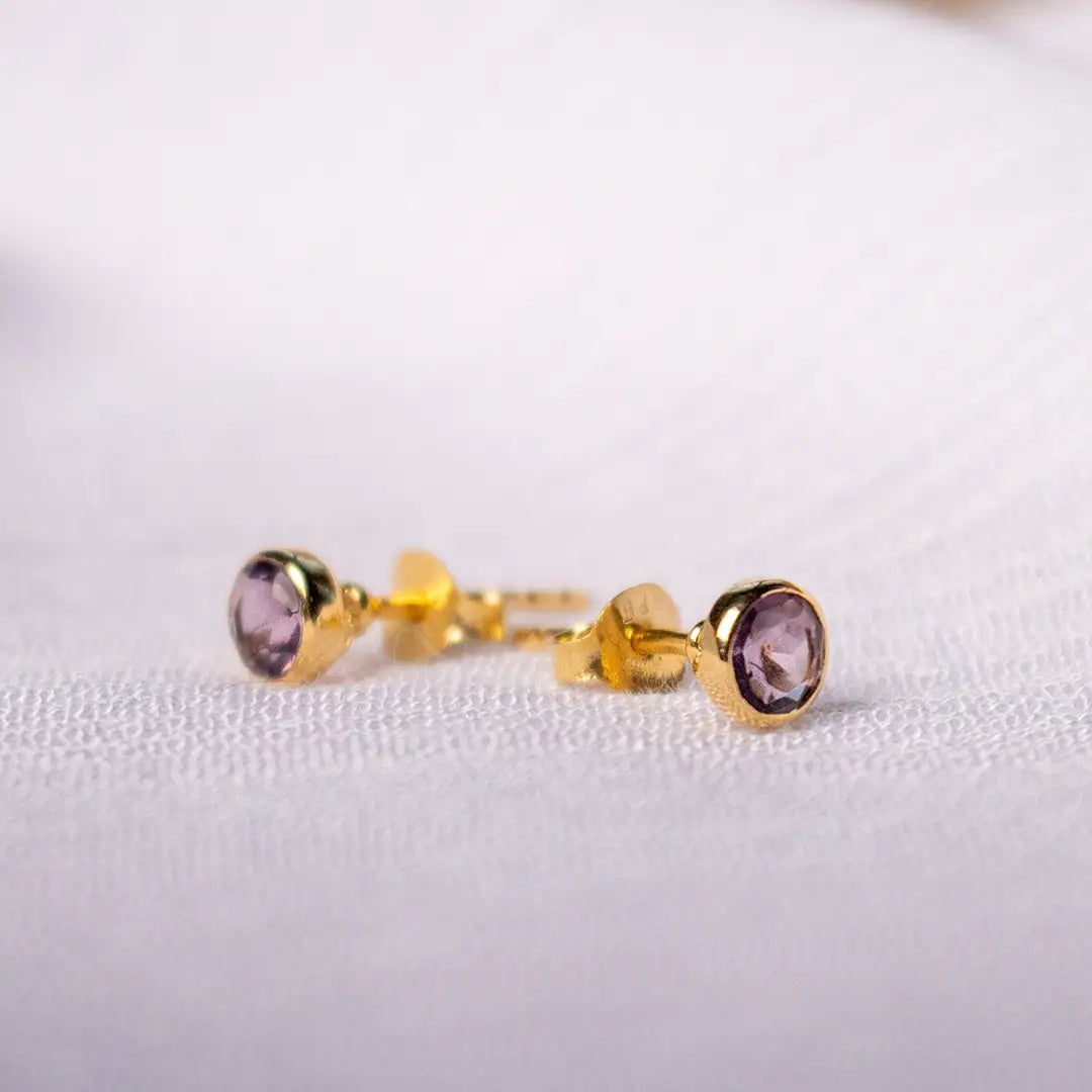 Side view of gold vermeil amethyst stud earrings showing bezel setting and butterfly backs, featuring purple February birthstone gemstones.