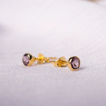 Side view of gold vermeil amethyst stud earrings showing bezel setting and butterfly backs, featuring purple February birthstone gemstones.