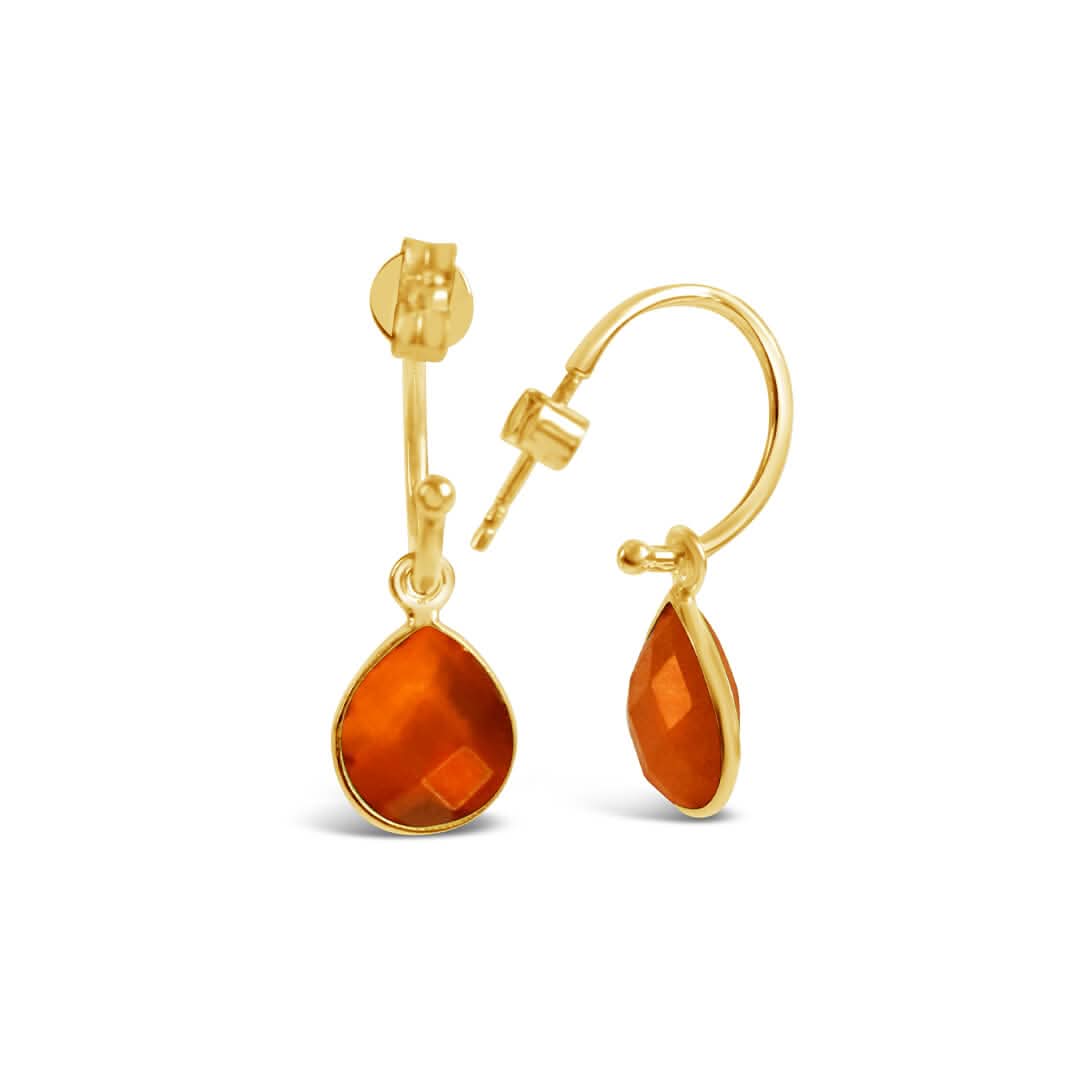 yellow gold hoop earring with teardrop shaped carnelian gemstone, against a white background.