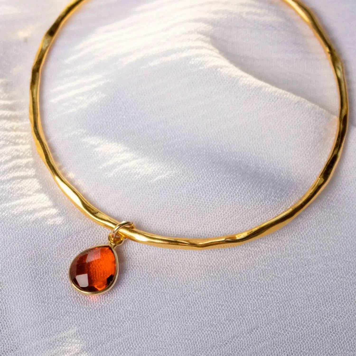 Close up of Gold Carnelian charm bangle