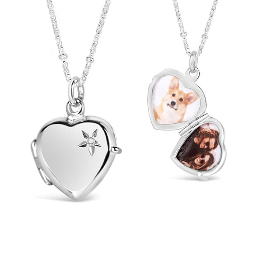silver heart shaped locket necklace featuring a small white diamond in the top left corner on a beaded chain and also shown open with photos of a dog and a couple inside. All on a white background
