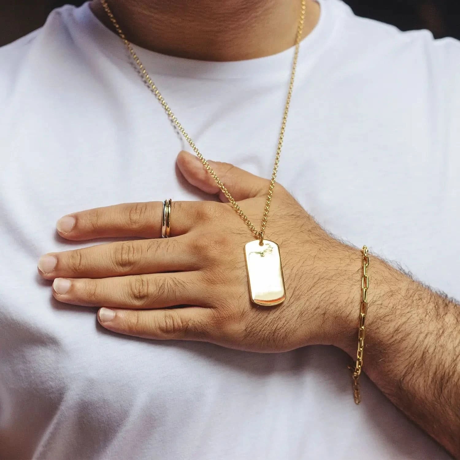 model wearing gold dog tag with chain