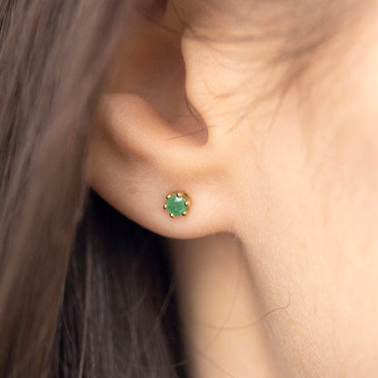 4mm real emerald stud earrings in 9 carat gold setting by Lily Blanche shown on model with brown hair