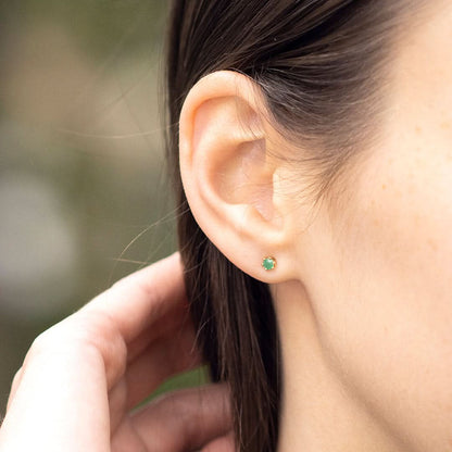 4mm real emerald stud earrings in 9 carat gold setting by Lily Blanche shown on model with brown hair