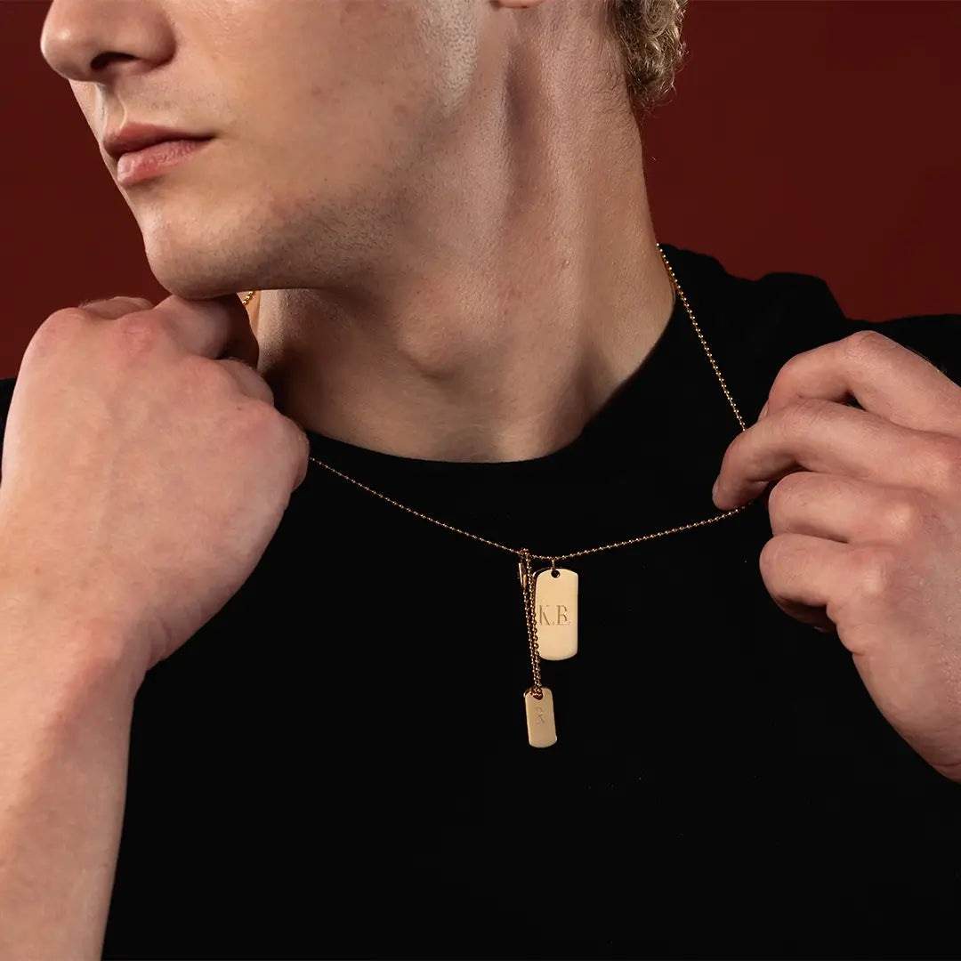 Male model wearing an engraved double gold vermeil dog tag necklace on a 24-inch popcorn chain