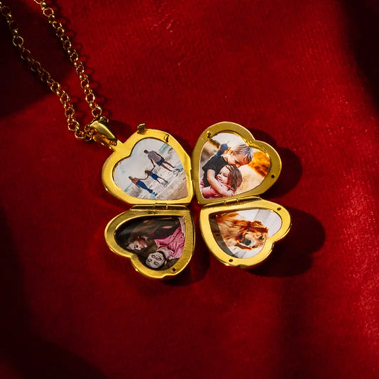 Gold four-photo heart locket necklace opened to display four personalised photos, placed on a rich red fabric background with soft lighting highlighting the polished gold finish.