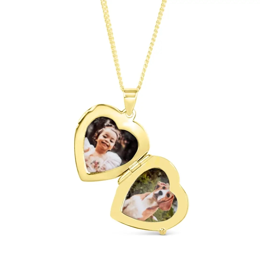 Open gold heart locket necklace displaying two photo inserts — one of a young girl and one of a dog — on a fine gold chain.