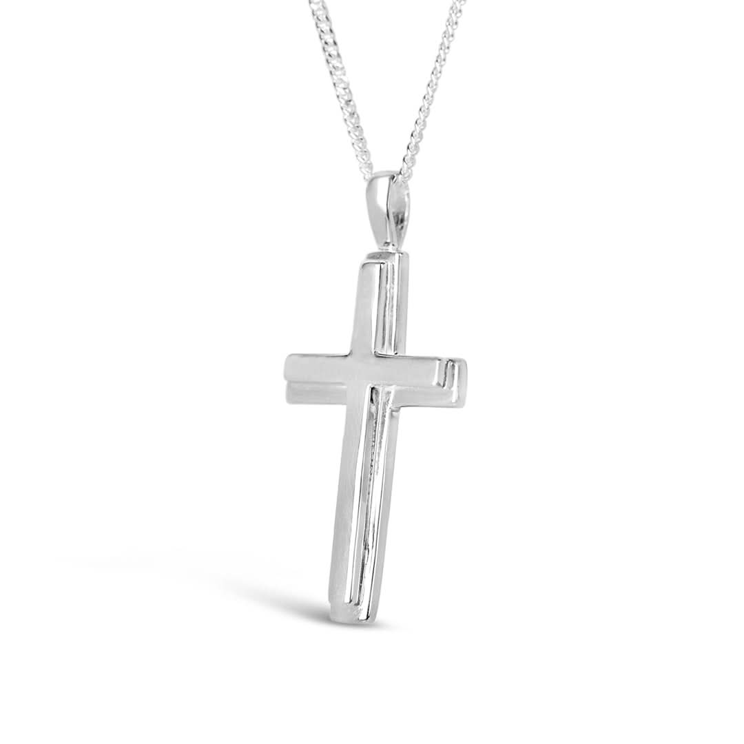 image of a heavy weight silver cross necklace from the side hanging on a curb chain and against a white background 