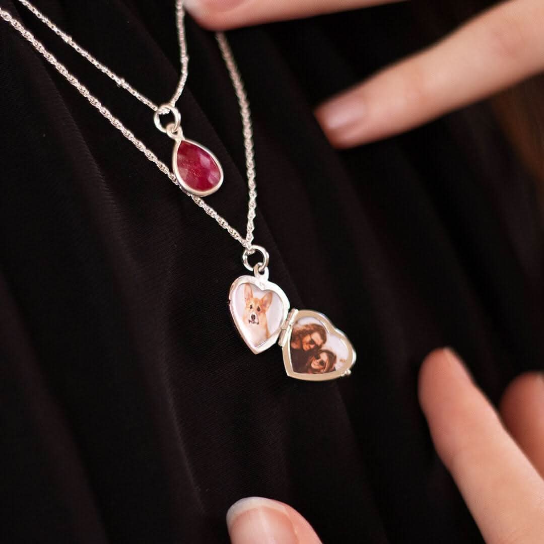model in black top wearing a two photo diamond heart locket in silver, open to show two photos inside.