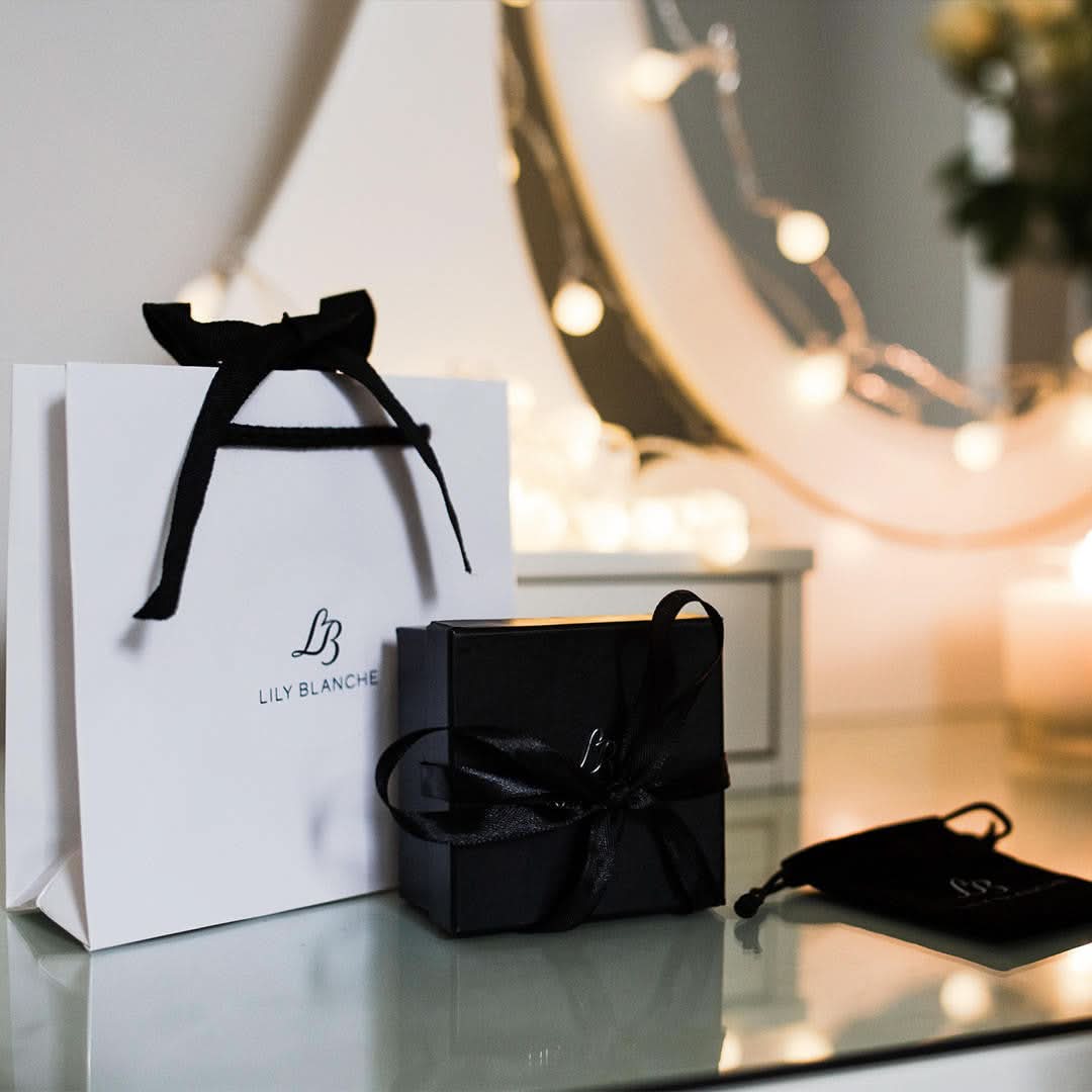 luxury ribbon tied white lily blanche gift bag, black ribbon tied lily blanche gift box, black lily blanche storage pouch