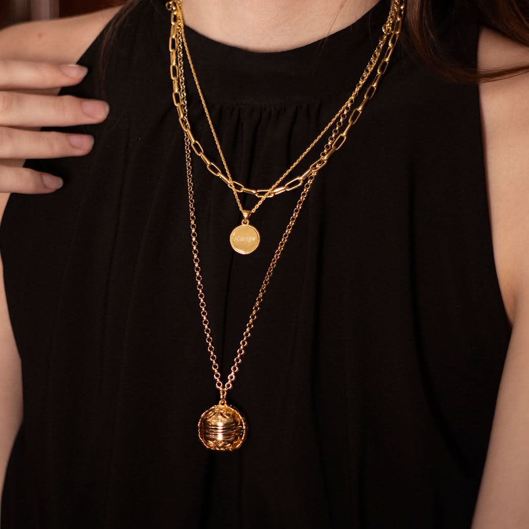 Layered gold necklaces with engraved coin pendant and vintage memory keeper locket