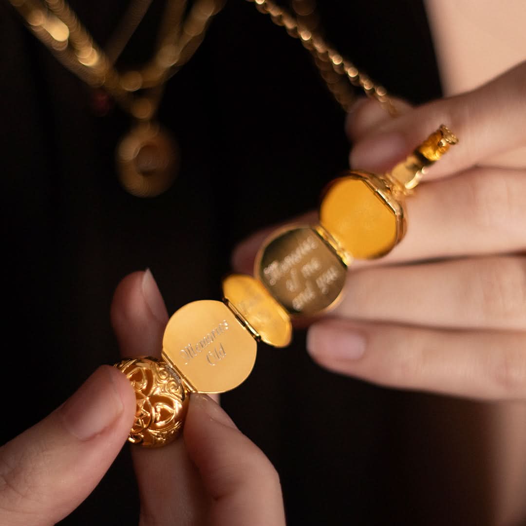 Close-up of opened gold memory keeper locket with engraved message inside