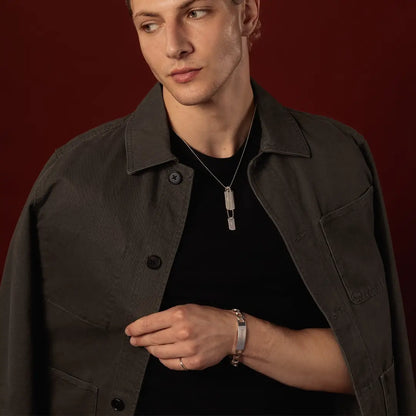 Male model wearing a sterling silver double dog tag necklace against a dark red background