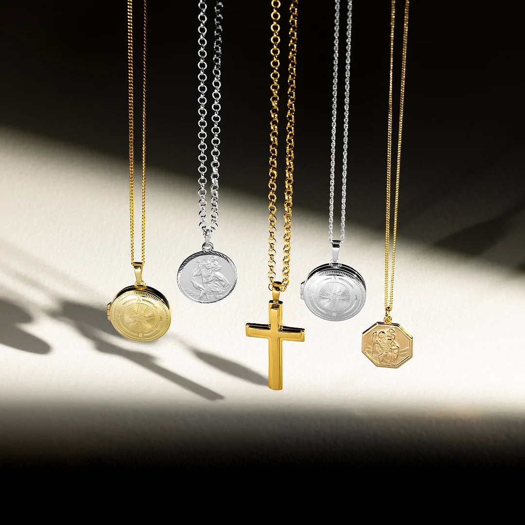 	
Lily Blanche men's jewellery collection — gold locket, silver St Christopher necklace, gold cross necklace, silver compass locket and gold octagonal St Christopher hanging on chains