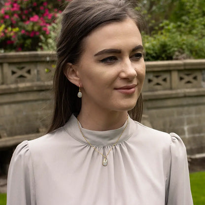 Gold moonstone initial necklace and matching moonstone drop earrings worn by a model, featuring faceted moonstone gemstones set in gold vermeil.