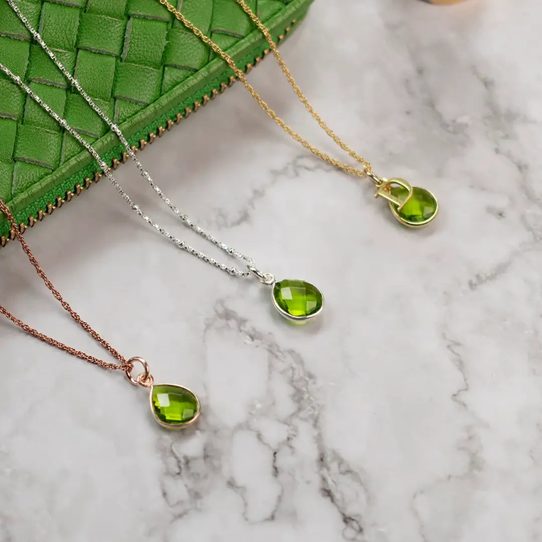 Peridot charm necklaces in sterling silver, 18ct gold vermeil and rose gold vermeil, each set with a faceted green peridot gemstone on delicate chains.