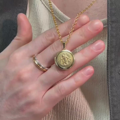 man wearing a gold round locket with a detailed relief of St Christopher on the font