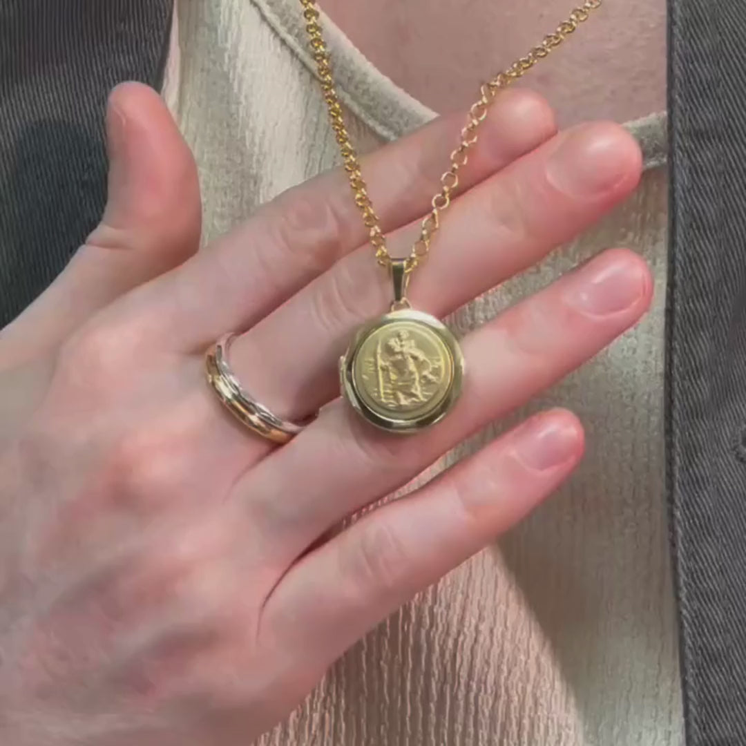 man wearing a gold round locket with a detailed relief of St Christopher on the font