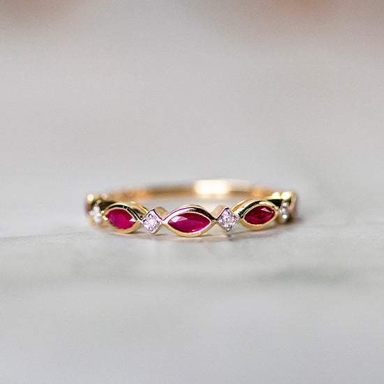 Gold ruby eternity ring with marquise-cut rubies and diamond accents