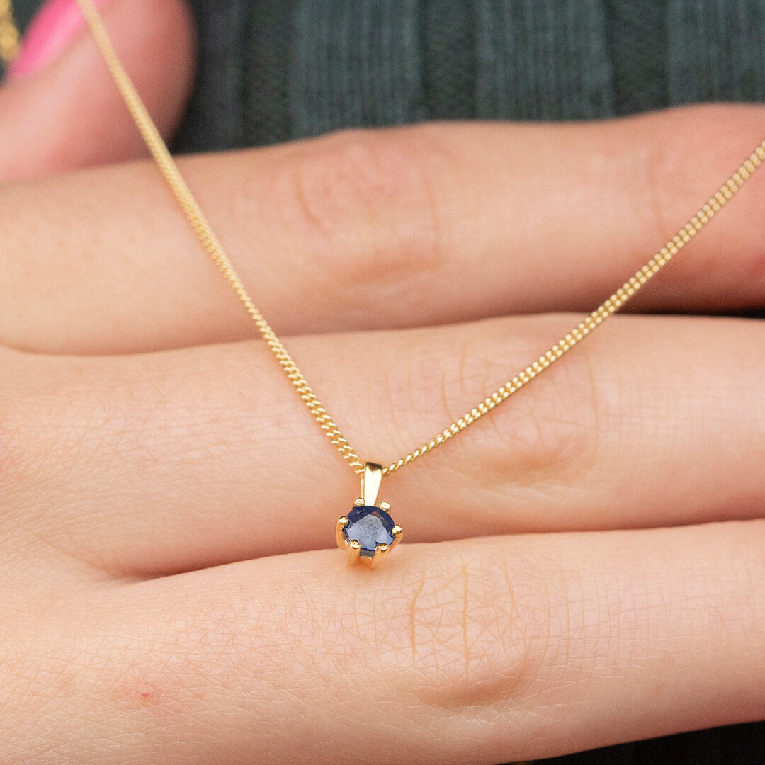 sapphire solataire necklace 5 mm in 9 carat gold setting and chain by Lily Blanche on hand