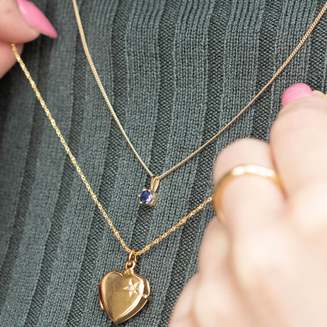 sapphire solataire necklace by Lily Blanche layered with a gold diamond heart locket