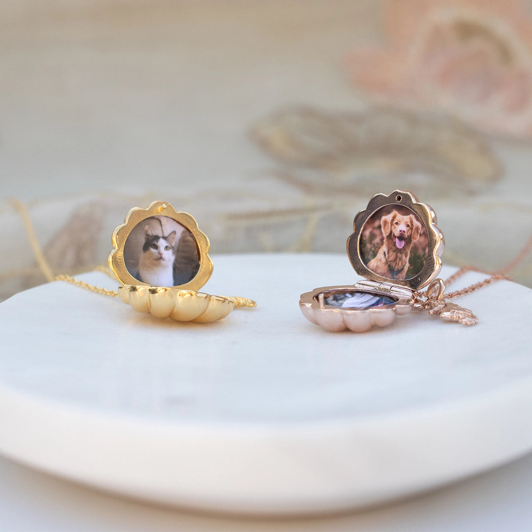 Gold and rose gold scallop shell photo lockets with seahorse charms, shown open and closed on a white display surface.