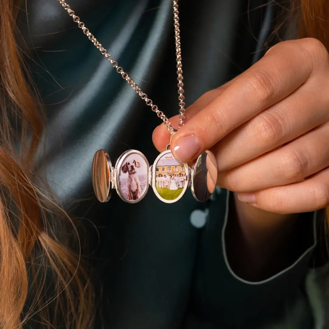 Close-up of sterling silver six-photo expanding oval locket opened fully, showing personalised pet and family images inside polished oval compartments on a silver chain.