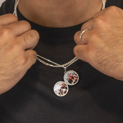 man wearing a silver chain necklace with two photos inside on a black t-shirt