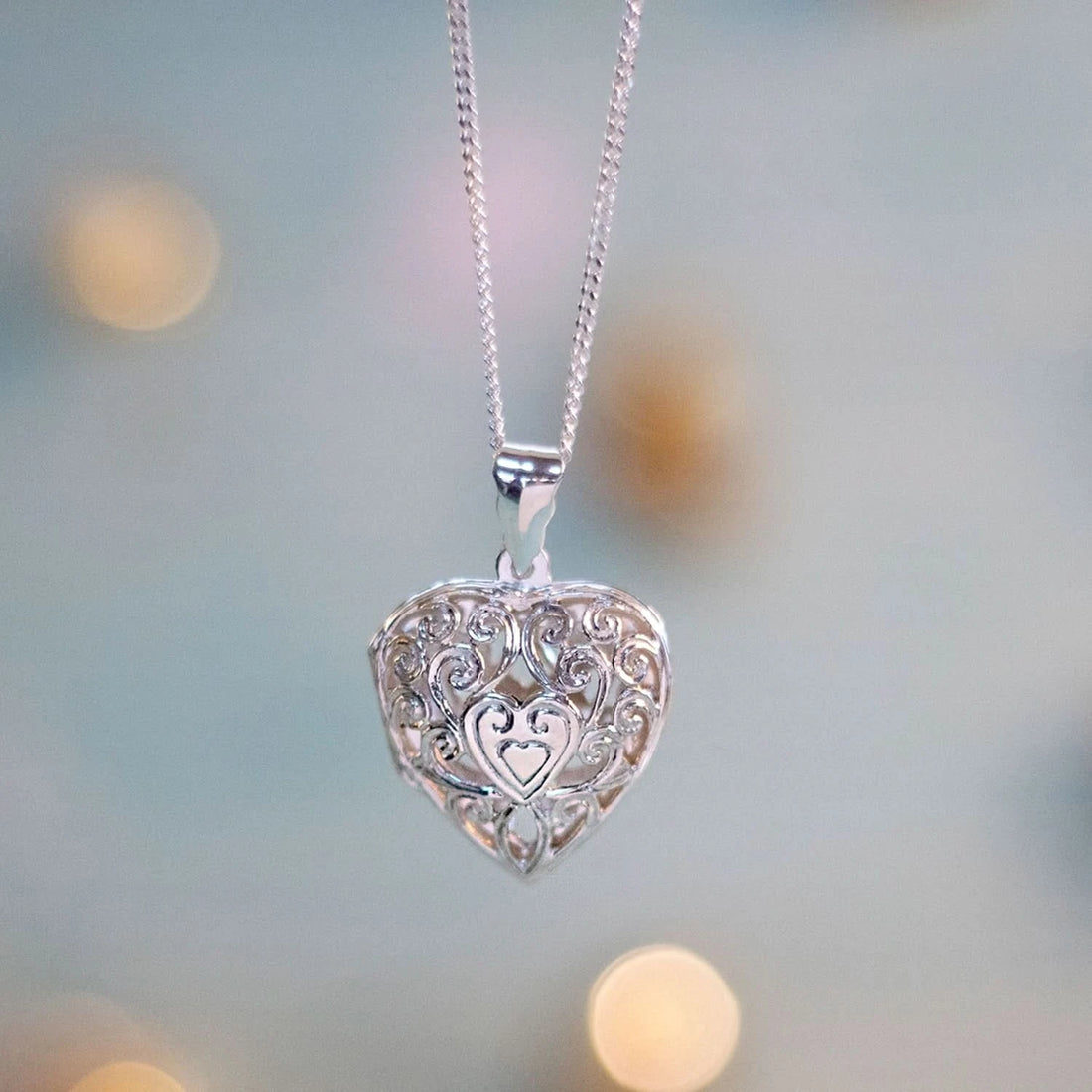 Filigree heart locket in silver on a blue background