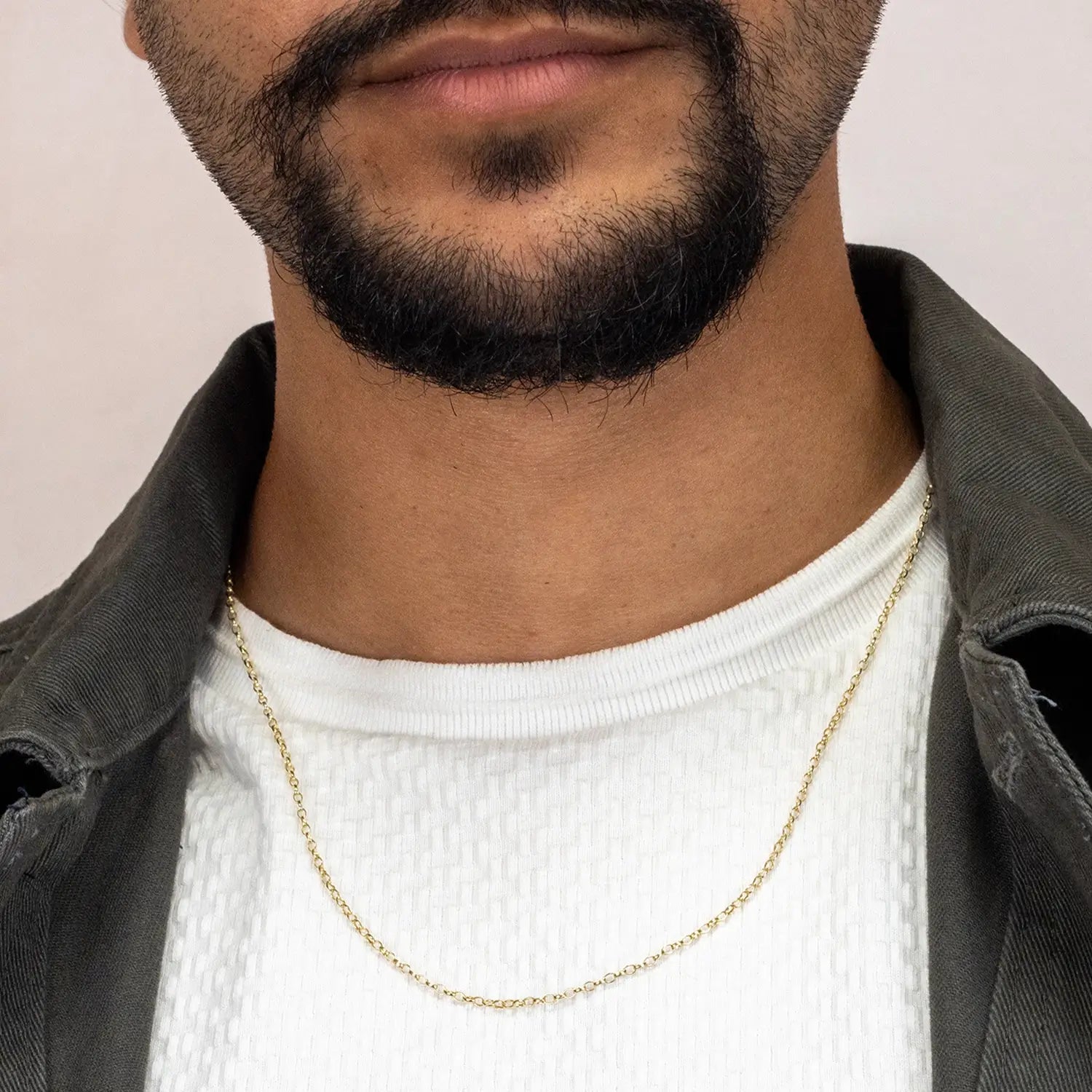 Man wearing a solid 9 carat gold belcher chain necklace with a neutral background