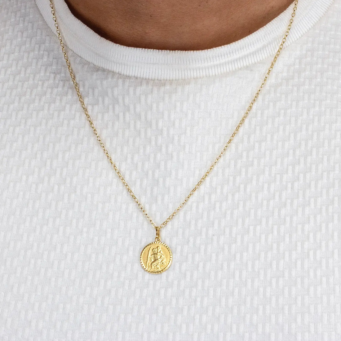 Gold st Christopher necklace with a round pendant on a white background