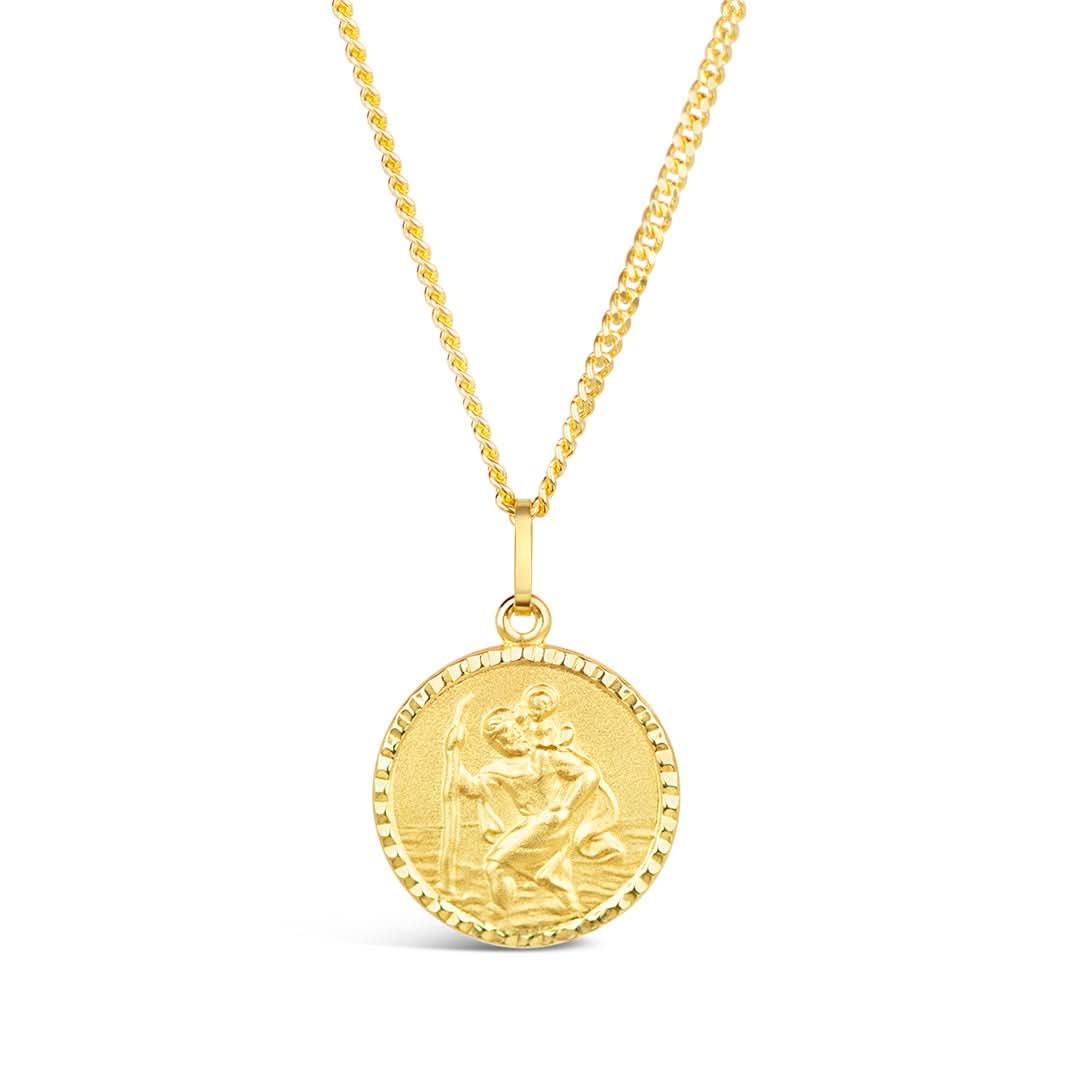A solid gold necklace featuring a traditional raised relief portrait of St Christopher carrying a child, with a matte finish and a fine, milled edge. The necklace is displayed against a white background.